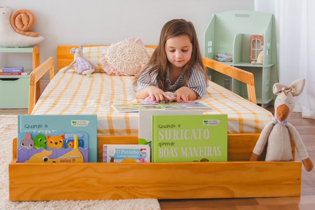 Criança de 3 anos lendo livro no quarto antes de dormir